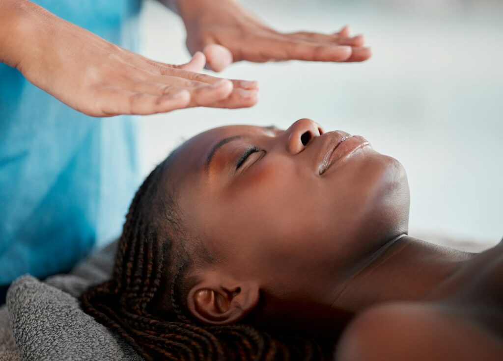 Black woman, reiki massage and luxury spa treatment of a young female ready for salon facial. Skinc