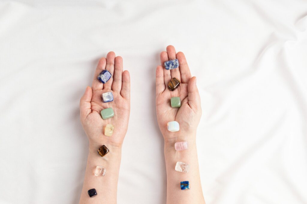 Healing reiki chakra crystals on woman's hands. Gemstones for wellbeing, meditation, relaxation